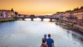 Lovers make a sephi on the bridge in Florence, Italy at sunset