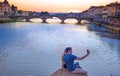 Lovers make a sephi on the bridge in Florence, Italy at sunset