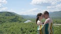 Lovers. Naked couple embracing covered by blanket. Guy embraces girl on green mountains background.