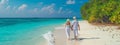 Lovers walk along the beach in the Maldives. Selective focus.