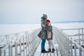 Lovers warm each other with love and hugs on a winter walk along the pier on the lake Royalty Free Stock Photo