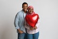 Lovers holding red heart shaped balloon and hugging Royalty Free Stock Photo
