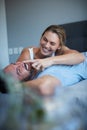 She loves being playful with him. an attractive young woman being playful with her husband while lying in bed in the Royalty Free Stock Photo