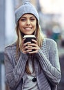 She loves her coffee. Portrait of a beautful young woman drinking coffee while out in the city.