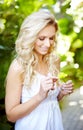 He loves me...He loves me not. Pretty young woman picking the petals of a daisy outdoors. Royalty Free Stock Photo