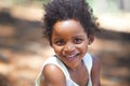 She loves playing in the woods. Portrait of an adorable little girl smiling at the camera while enjoying a day outdoors. Royalty Free Stock Photo