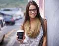 She loves working in the City. A gorgeous young woman enjoying some coffee while checking out the city. Royalty Free Stock Photo