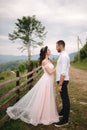 Lovestory of beautiful couple in the mountains, Handsome bearded man with beautiful and charming woman. Couple stand in