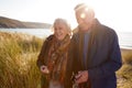 Loving Active Senior Couple Arm In Arm Walking Through Sand Dunes Royalty Free Stock Photo