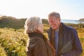 Loving Active Senior Couple Walking Along Coastal Path In Autumn Together Royalty Free Stock Photo