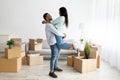 Loving african american couple celebrating moving day, guy lifting his wife in their new apartment Royalty Free Stock Photo