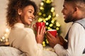 Loving african-american couple drinking tea against Christmas tree Royalty Free Stock Photo
