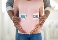 Loving African American couple holding BOY and GIRL cards near pregnant belly, close up view