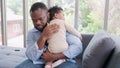 Loving African American dad embracing baby and baby girl sleeping on stepfather shoulder. Happy family with pleasure spending time