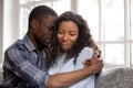 Loving African American husband embracing wife after quarrel