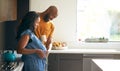 Loving African American Husband With Pregnant Wife At Home In Kitchen Together