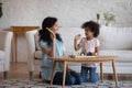 African mother giving high five, praises daughter for chess victory