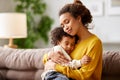Loving afro american mom cuddling with little kid son while relaxing on sofa Royalty Free Stock Photo
