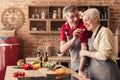 Loving aged man feeding his wife with cucumber in kitchen Royalty Free Stock Photo