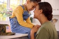 Loving American Army Mother In Uniform Home On Leave Hugging Daughter In Family Kitchen