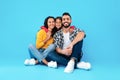 Loving Arab Family Hugging Sitting In Studio Over Blue Background
