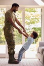 Loving Army Father In Uniform Home On Leave With Son Standing On Feet And Holding Hands