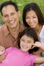 Loving Asain parents and their daughters smiling.