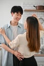 Loving Asian couple dancing in the kitchen, having happy and romantic moment together Royalty Free Stock Photo