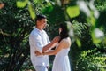 Loving asian couple in white clothes spending time in a park