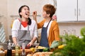 Loving Asian family of mother and daughter cooking in kitchen