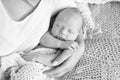 Loving baby sleeping in mother`s hands. Closeup picture. Happy mother and her slipping newborn baby in the bed Royalty Free Stock Photo