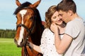 Loving beautiful couple of guys and girls in the field walk on horses Royalty Free Stock Photo