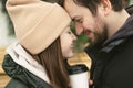 Loving beautiful couple on a winter day. A man hugging his happy woman, drinking hot tea or coffee while walking in the Royalty Free Stock Photo