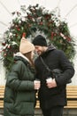 Loving beautiful couple on a winter day. A man hugging his happy woman, drinking hot tea or coffee while walking in the Royalty Free Stock Photo