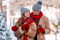 Loving beautiful couple with coffee to go enjoying snowy day Royalty Free Stock Photo