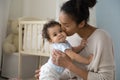 Loving biracial mom hug and kiss little baby Royalty Free Stock Photo