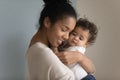 Loving biracial mum hug little baby girl Royalty Free Stock Photo