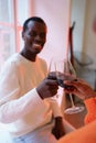 Loving black couple hold glasses with red wine toasting. Young african family spend weekend at home Royalty Free Stock Photo