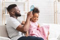 Loving black father brushing his cute daughter hair Royalty Free Stock Photo