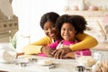 Loving Black Mom And Daughter In Aprons Posing At Table In Kitchen Royalty Free Stock Photo