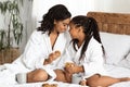 Loving Black Mom And Daughter In Bathrobes Bonding At Home, Eating Snacks Royalty Free Stock Photo