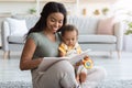 Loving Black Mom Reading Book For Her Cute Infant Baby At Home Royalty Free Stock Photo