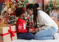 Loving black mother giving Christmas present to her little daughter Royalty Free Stock Photo