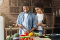 Loving black wife hugging husband while cooking