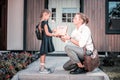 Loving blonde-haired father making little surprise for his cute schoolgirl