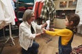 Loving caring grandmother smiles as she looks at her granddaughter`s drawing while working in a tailoring and designing atelier Royalty Free Stock Photo