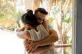 Loving caucasian young couple embracing while standing in balcony seen through cottage doorway Royalty Free Stock Photo