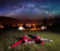 Loving couple admiring bright stars and lying on the grass Royalty Free Stock Photo