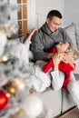 Couple in love celebrate winter Christmas together. Man and woman together on couch near Xmas tree Royalty Free Stock Photo