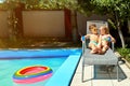 Loving couple child kids on a lounger by the pool in the summer.